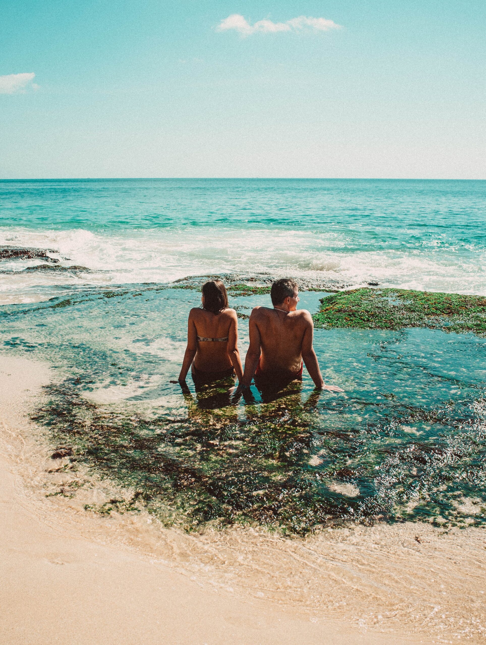 Couple sitting in a beach in Bali.